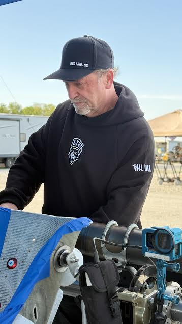Pivot Racing mechanic working on a race kart engine at the track
